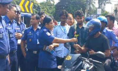 হেলমেট পরা মোটরসাইকেল চালকদের পুলিশের ফুলেল শুভেচ্ছা